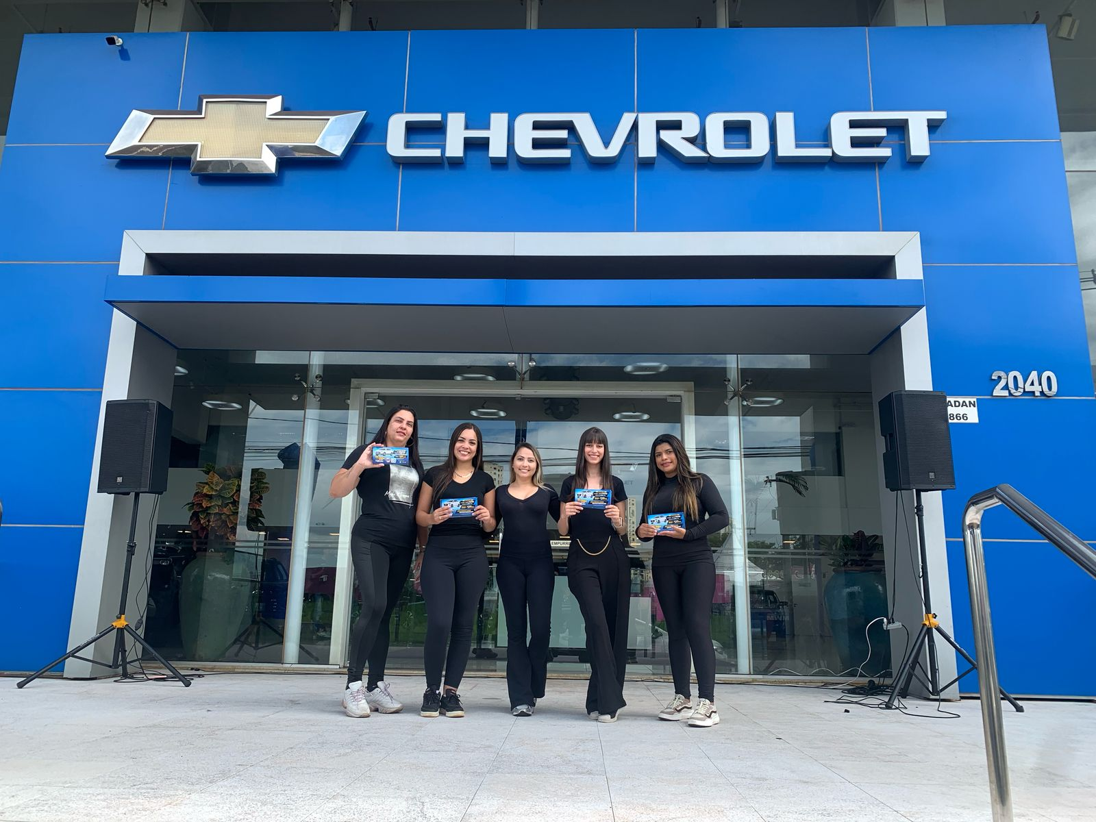 Equipe de promotoras na fachada da concessionária Chevrolet